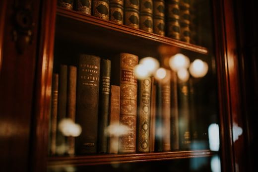 A warm lamp-lit cabinet of law books